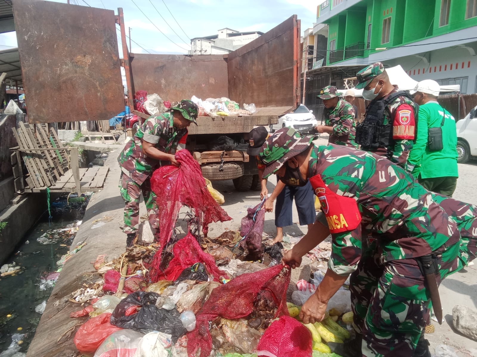 Anggota TNI Bersama Warga Bersihkan Sampah Di Pasar Induk Wonomulyo
