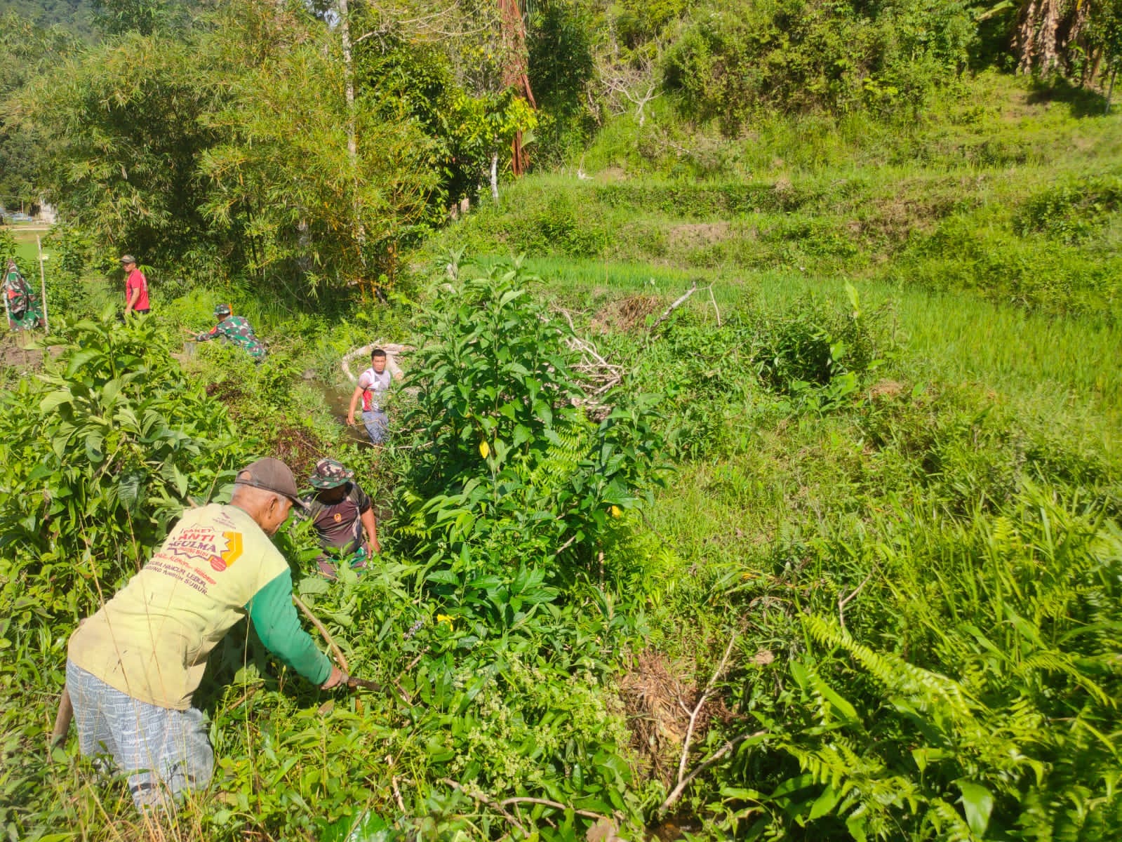 Koramil Mambi Bantu Masyarakat Bersihkan saluran air untuk kelancaran pengairan persawahan