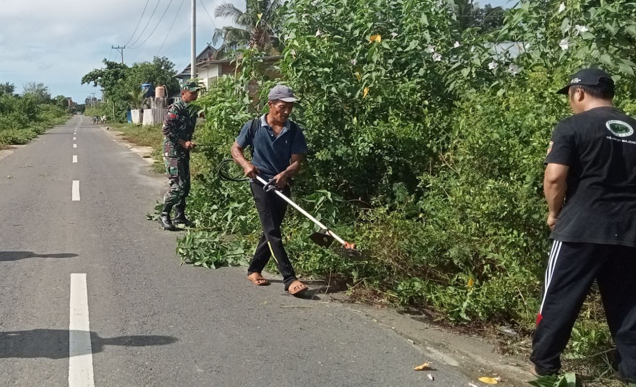 Motivasi Warga Binaan, Babinsa Bergotong-Royong Bersihkan Bahu Kiri Kanan Jalan