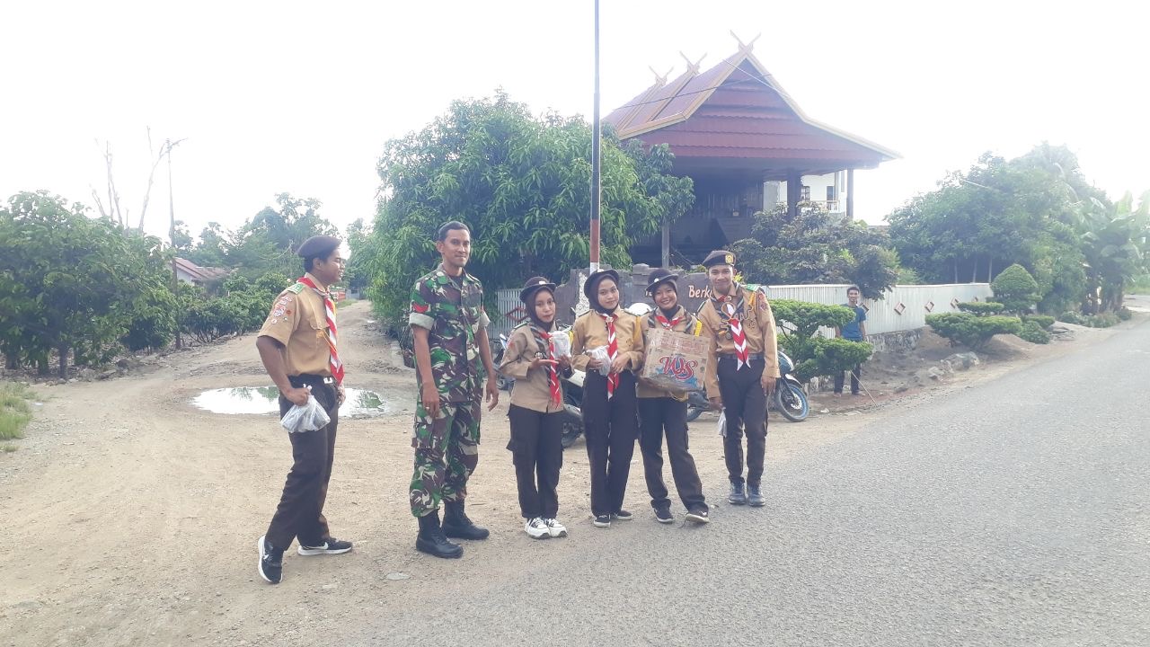Babinsa Koramil 1420-01/Panca Lautang Bersama Siswa SMK Negeri 8 Sidrap Bagikan Takjil Pada Pengguna Jalan