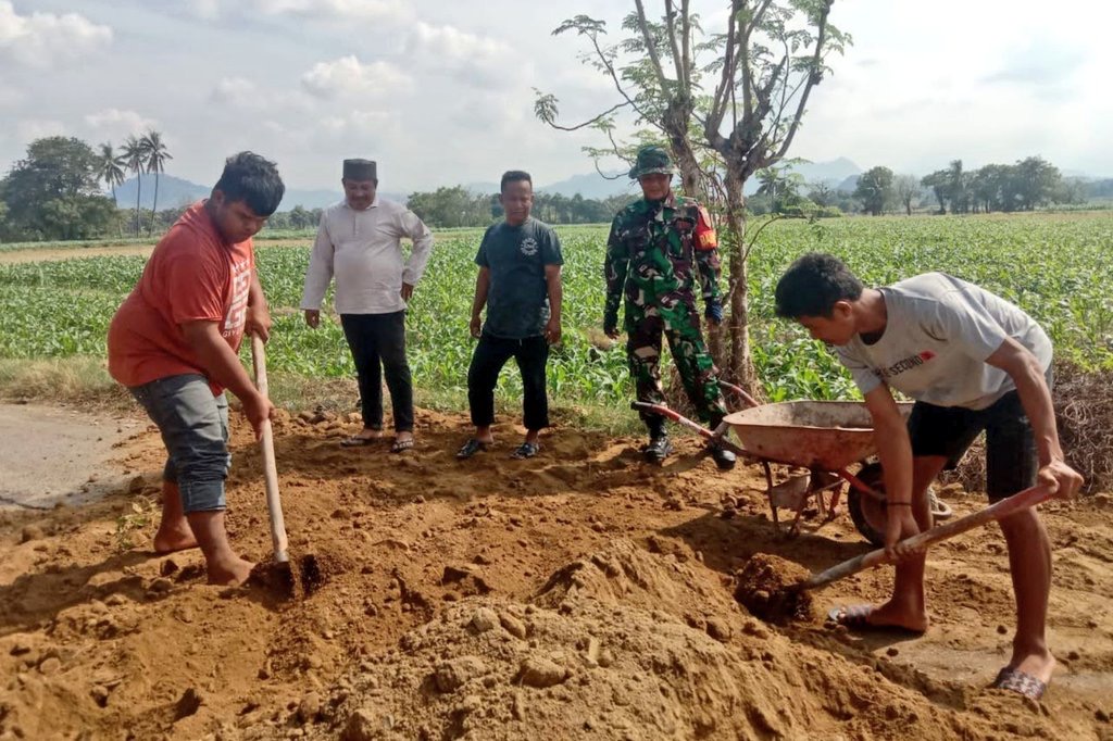Peduli Keselamatan Masyarakat, Babinsa Koramil Tamalatea Bersama Warga Gotong Royong Penimbunan Jalan Berlubang