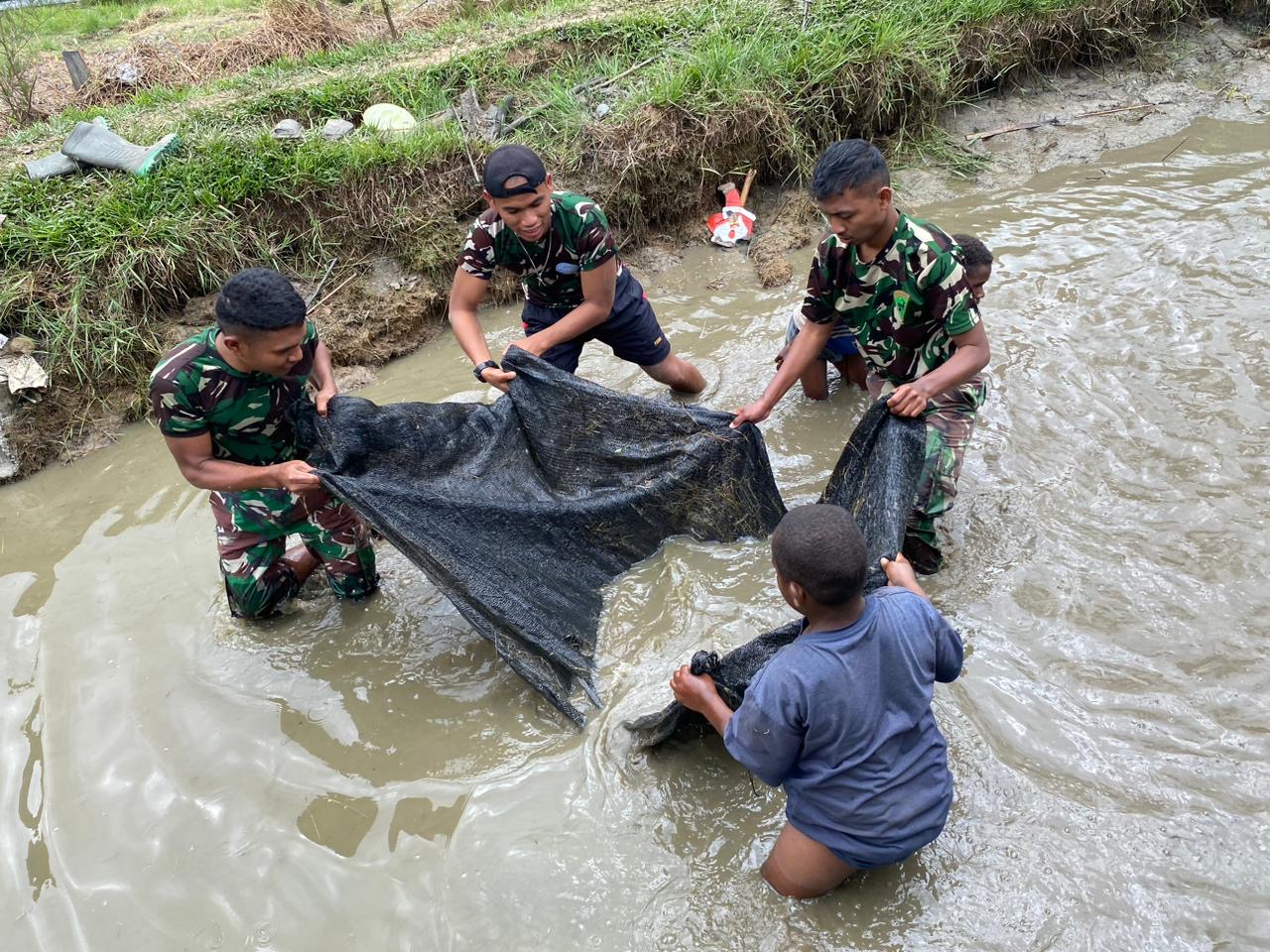 Cara Satgas Yonif 721/Mks Berbagi Kebahagiaan Dengan Mengajak Masyarakat Papua Panen Ikan Bersama